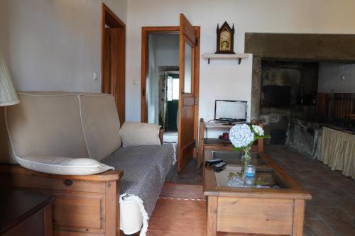 a living room with a couch and a fireplace at Casa do ti' Marrão in Praia da Vitória