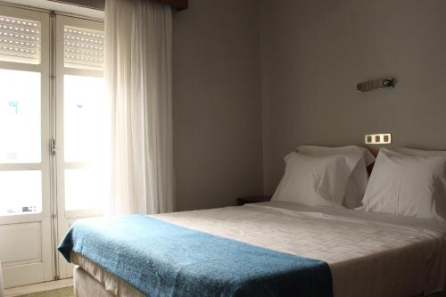 una camera da letto con un letto con una coperta blu sopra di Casa do Lugar de Paços a Caldelas