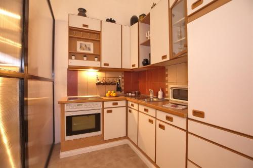 eine kleine Küche mit weißen Schränken und einem Kühlschrank in der Unterkunft Kahwa Apartments in Budapest