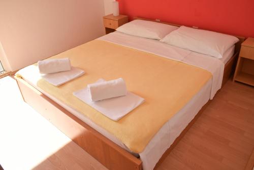a bedroom with a bed with two white towels on it at Villa Galeb Pag - at the main Beach in Pag