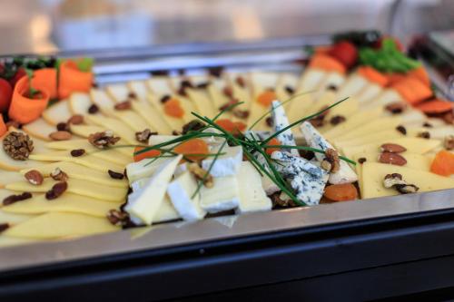 una bandeja de comida con queso y verduras. en Villa Dvor Kornic, en Budva