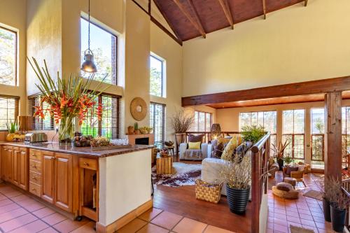 an open kitchen with a living room with a couch at Ulwazi Rock Lodge in Hazyview