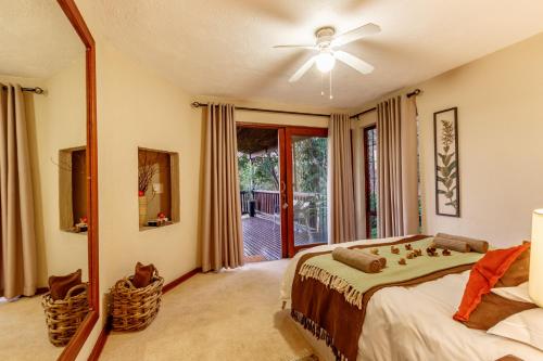 a bedroom with a bed with a ceiling fan and a mirror at Ulwazi Rock Lodge in Hazyview