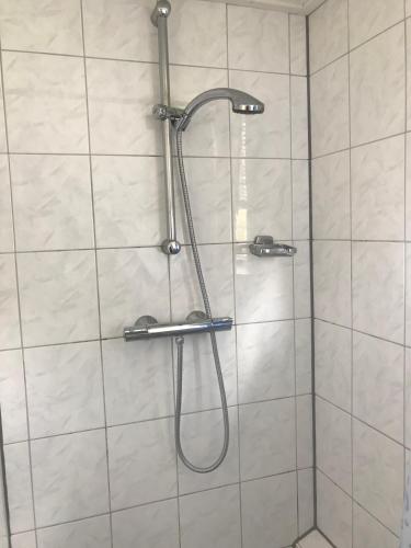a shower with a shower head in a bathroom at De Sloep in Bergen