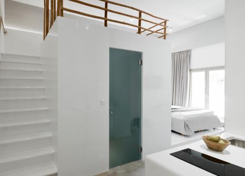 a white room with a bed in the background at Arco Solium Suites in Adamas