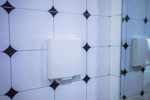 a bathroom with black and white tiled walls and a urinal at Murphy Youth Hostel Guilin桂林北站莫非青年旅舍 in Guilin