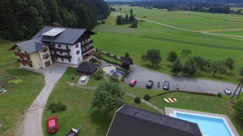 an aerial view of a house with cars parked in a field at Hotel-Pension Birkenhof in Kötschach