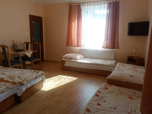 ブワディスワボボにあるRodzinna Przystańのベッド2台、窓(テーブル付)が備わる客室です。