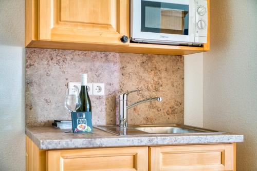 a kitchen counter with a sink and a microwave at Gästehaus Weingut Politschek in Bad Friedrichshall