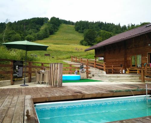 basen z parasolem obok kabiny w obiekcie Cottage Kurshevel w Sławsku