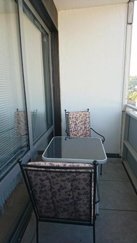 einen Stuhl auf einem Balkon mit einem Tisch in der Unterkunft Suite Olivier in Saarbrücken