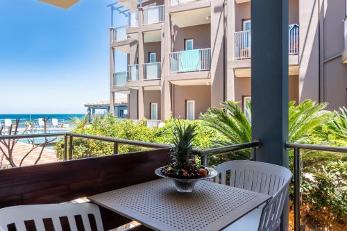 a table and chairs on a balcony with a view of the beach at Girogiali beach hotel - Adults only in Stalos