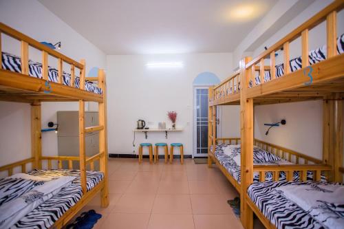 a room with three bunk beds in a room at Murphy Youth Hostel Guilin桂林北站莫非青年旅舍 in Guilin
