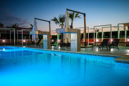 a swimming pool at night with chairs and a building at Boutique Apartments Blitz in Bibinje