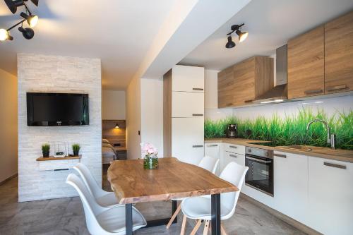 a kitchen with a wooden table and white chairs at Chilly apartment in Bled