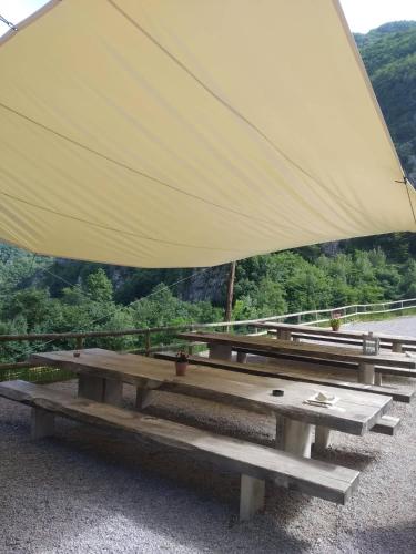 a picnic table with a large white umbrella at Limarò B&B in Sarche di Calavino