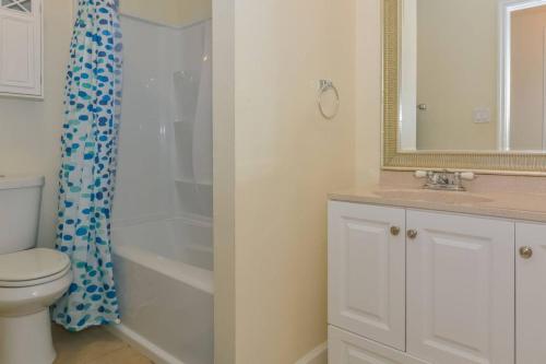a bathroom with a shower and a toilet and a sink at Lovely Cottage near the Beach and Downtown Sarasota in Sarasota