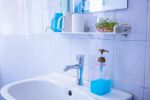a bathroom with a sink with a toothbrush holder on it at Murphy Youth Hostel Guilin桂林北站莫非青年旅舍 in Guilin