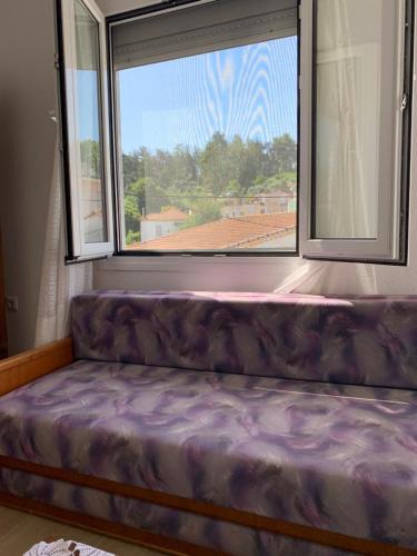 a couch in a room with a large window at Acropolis view apartment in Limenas