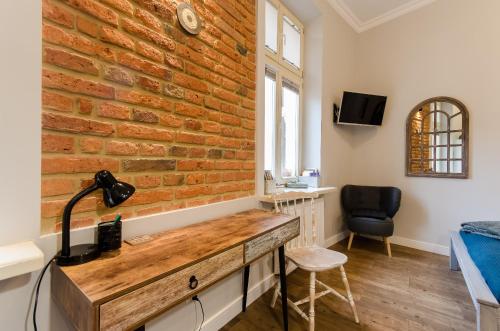 a brick wall in a room with a desk at Apartament EmeryK in Krakow