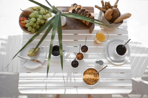 a table with food and drinks on it at Arco Solium Suites in Adamas