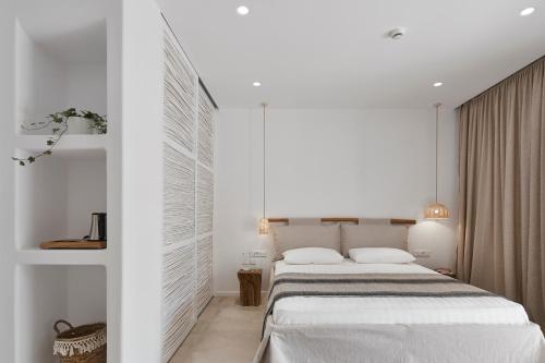 a white bedroom with a large bed in it at Arco Solium Suites in Adamas