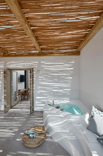 a bedroom with a large bed and a tub at Arco Solium Suites in Adamas