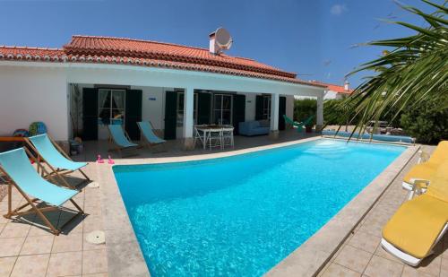 a villa with a swimming pool in front of a house at Holiday villa with pool near the ocean in Aljezur