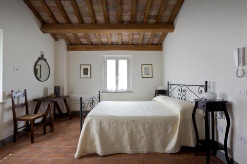 a bedroom with a bed and a table and a window at Molino Monacelli Country House in Fano