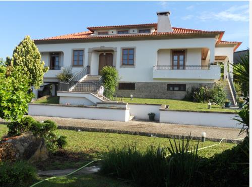 a large white house with stairs and a yard at Quinta da Ribeirinha in Arouca