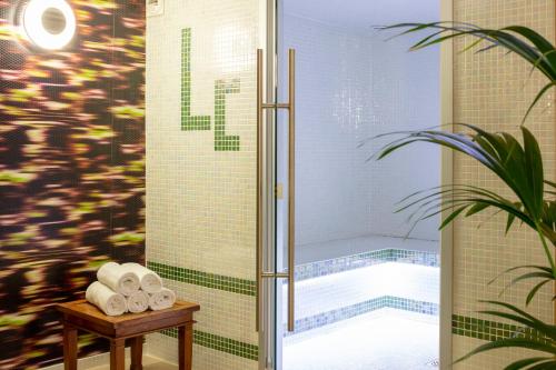 y baño con ducha y toallas sobre una mesa. en Hotel La Chaumière, en Quillan
