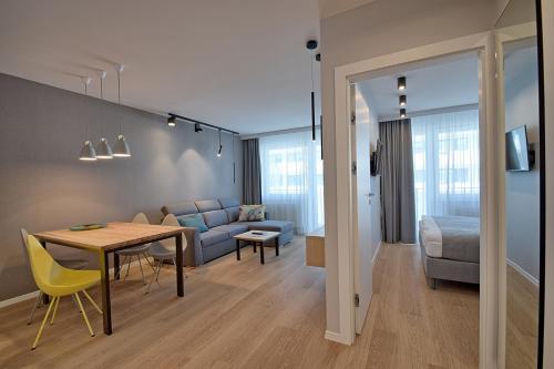 a living room and dining room with a table and a couch at Apartament PIER 72 PREMIUM in Kołobrzeg