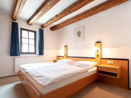 Un dormitorio con una cama grande y una ventana en Gästezimmer im Weingut Wolf en Großkarlbach