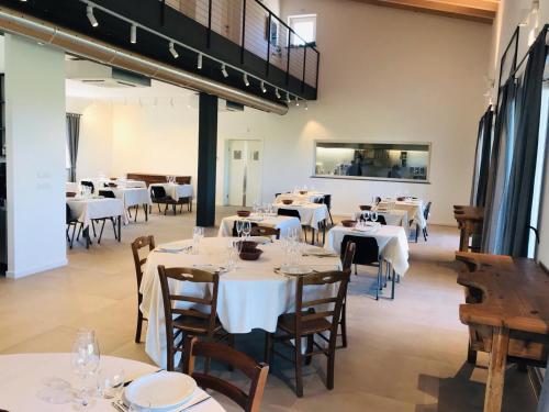 a dining room with white tables and chairs at Agriturismo Bacchanalis in Ziano Piacentino