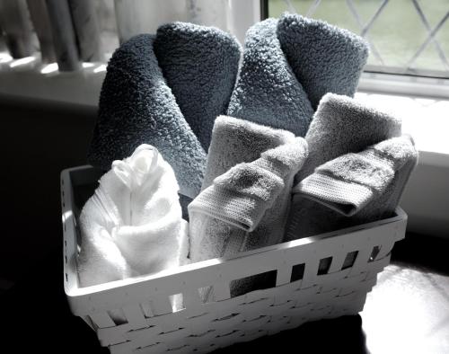 a basket filled with towels and socks next to a window at Fernbank Suite in Sheffield