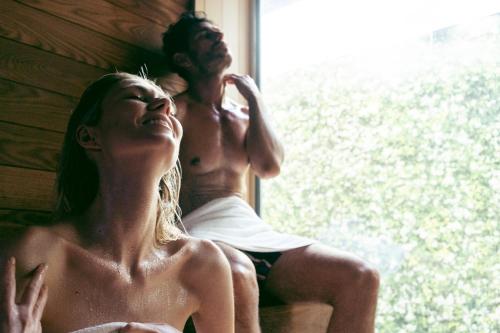 a man and a woman sitting next to a window at Ausonia Hungaria Wellness & Lifestyle in Venice-Lido