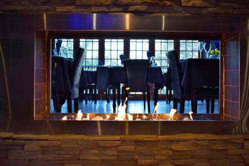 een open haard in een eetkamer met een tafel in de reflectie bij Waterfalls Boutique Hotel in Pretoria