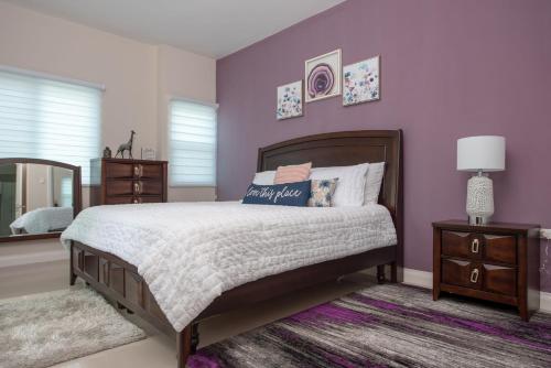 a bedroom with a bed and a purple wall at The Crimson Apartment in Kingston