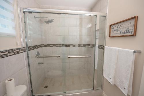 a shower with a glass door in a bathroom at The Crimson Apartment in Kingston