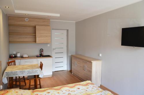 Pokoje Gościnne Bartek في ياستراوبيا جورا: غرفة مع مطبخ وغرفة طعام مع طاولة