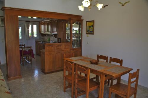 a kitchen with a wooden table and wooden cabinets at Stathoula's House in Kontokali