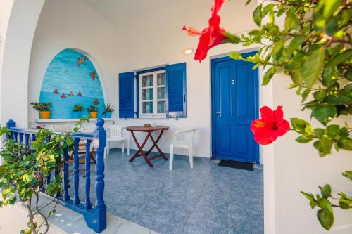 a room with blue doors and a table with a red flower at Villa Anna Maria in Aliki
