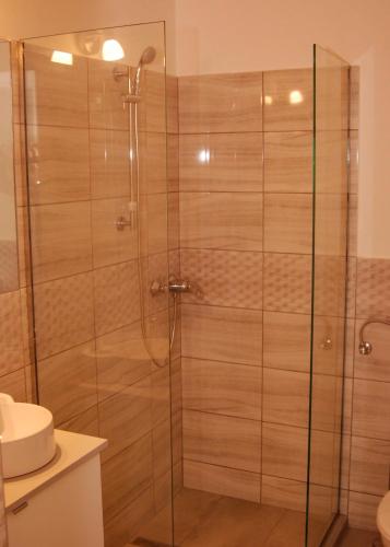 a shower with a glass door in a bathroom at Boutique Vendégház Vidéki Idill Noszvaj in Noszvaj