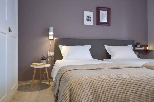 Un dormitorio con dos camas y una mesa con lámpara. en Vila White Tulip, en Alba Iulia