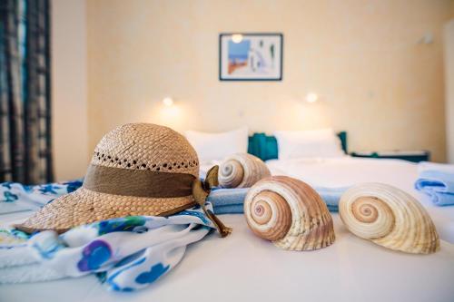 a hat and some seashells on a bed at Villa Anna Maria in Aliki