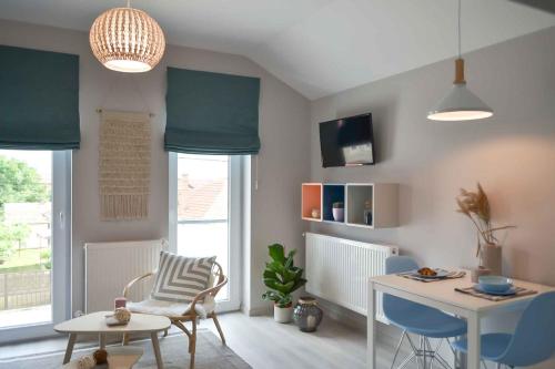 sala de estar con cortinas azules, mesa y sillas en Vila White Tulip, en Alba Iulia