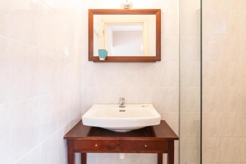 a bathroom with a sink and a mirror at Girogiali beach hotel - Adults only in Stalos