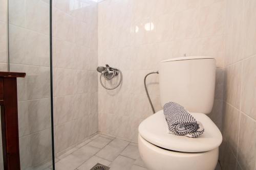 a bathroom with a toilet with a glass shower at Girogiali beach hotel - Adults only in Stalos