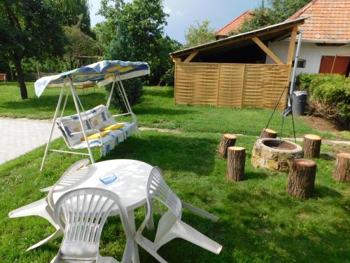 a swing and a chair in a yard at Boutique Vendégház Vidéki Idill Noszvaj in Noszvaj