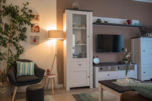 - un salon avec une télévision, une chaise et une armoire dans l'établissement Apartman Luna, à Šibenik